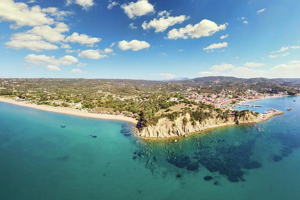 Finikounda fishing village and Anemomilos beach with windsurfers and crystal-clear Mediterranean waters